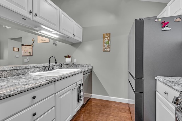 kitchen featuring a sink, stainless steel appliances, dark wood-type flooring, and white cabinetry