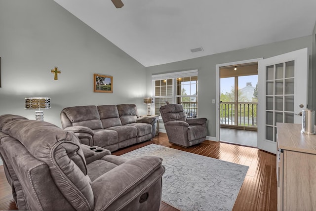 living room featuring hardwood / wood-style floors, high vaulted ceiling, baseboards, and ceiling fan