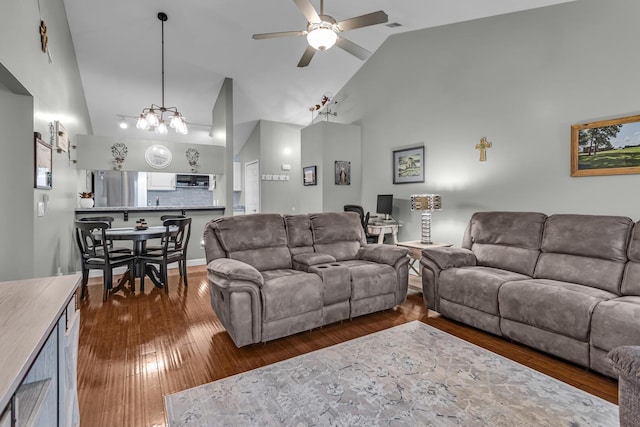 living area with high vaulted ceiling, ceiling fan, dark wood-style flooring, an office area, and a chandelier