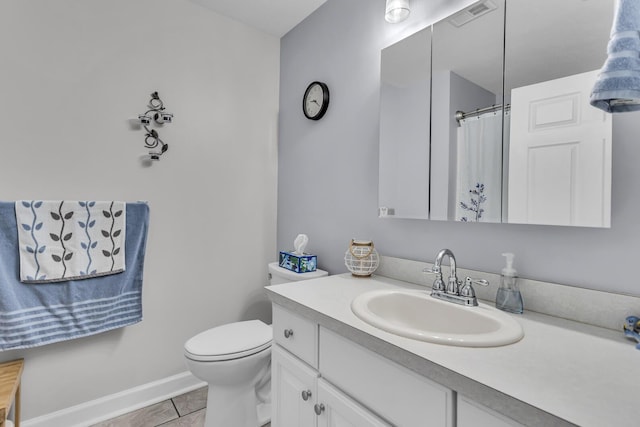 bathroom featuring vanity, tile patterned flooring, baseboards, and toilet