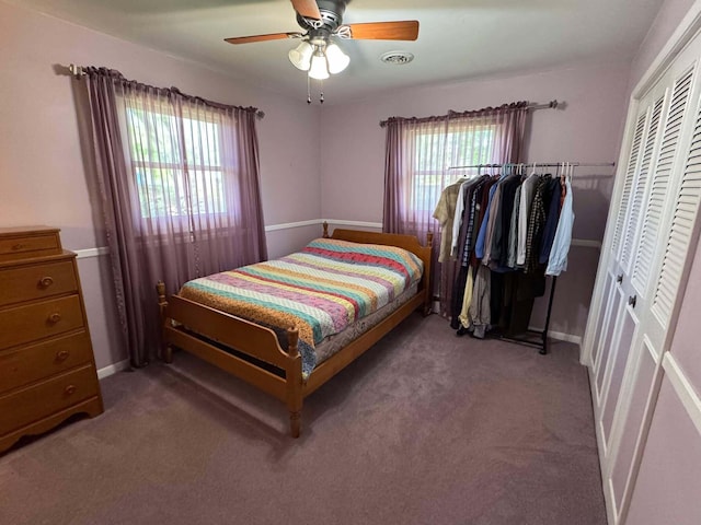 carpeted bedroom featuring a closet, ceiling fan, and baseboards