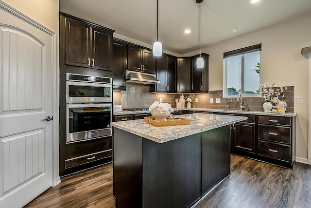 2767 St Regis Way, Ann Arbor, MI 48105 - kitchen with appliances with stainless steel finishes, a sink, dark wood-style flooring, light stone counters, and under cabinet range hood