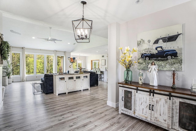 kitchen with open floor plan, a chandelier, lofted ceiling, ceiling fan, and wood finished floors