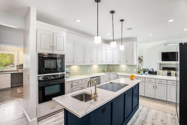 kitchen with black appliances, a sink, white cabinetry, backsplash, and recessed lighting