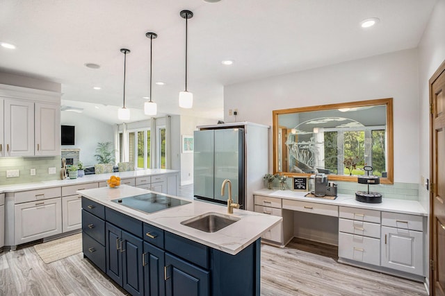 kitchen with a sink, an island with sink, black electric stovetop, plenty of natural light, and recessed lighting