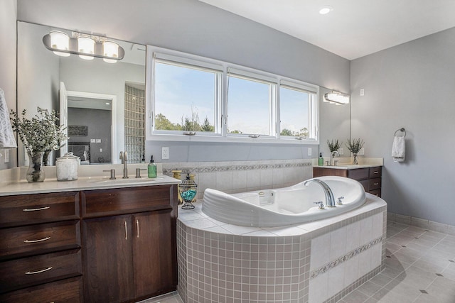 full bath with two vanities, a bath, tile patterned flooring, and baseboards