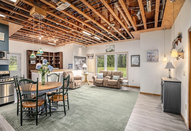 dining space featuring healthy amount of natural light, wood finished floors, and baseboards