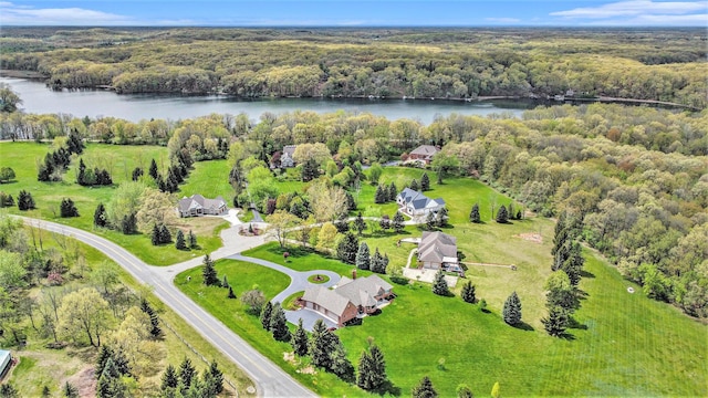 drone / aerial view of a heavily wooded area and a large body of water