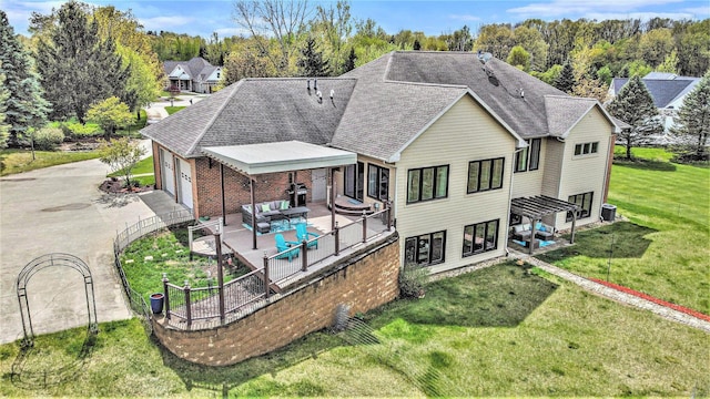 back of house featuring an outdoor hangout area, a yard, a garage, a shingled roof, and central AC unit
