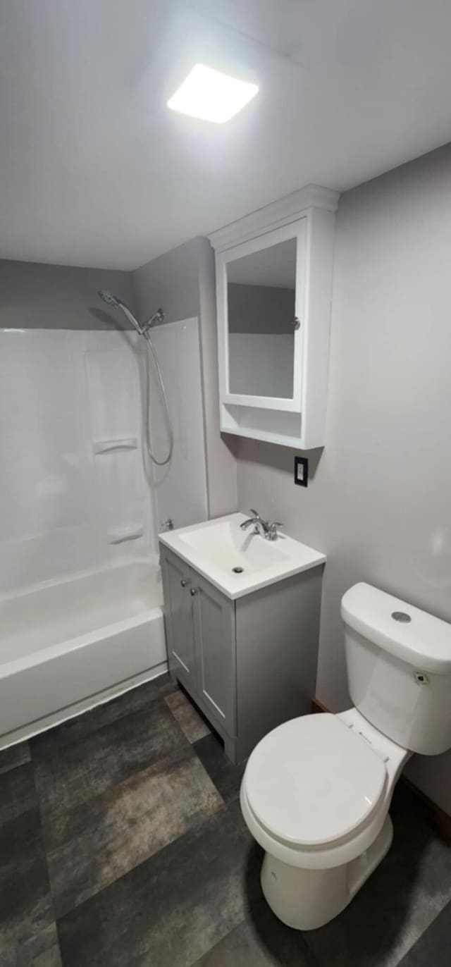 bathroom featuring toilet, vanity, and tub / shower combination