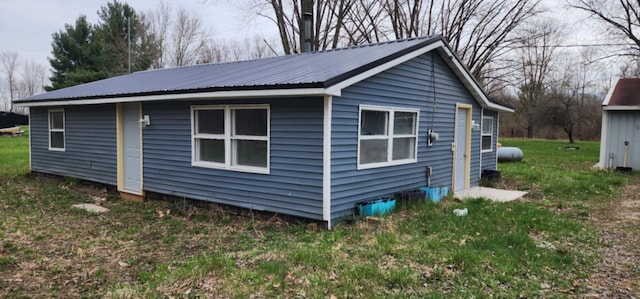 view of property exterior with metal roof and a yard