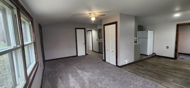 spare room with baseboards, ceiling fan, wood finished floors, recessed lighting, and lofted ceiling