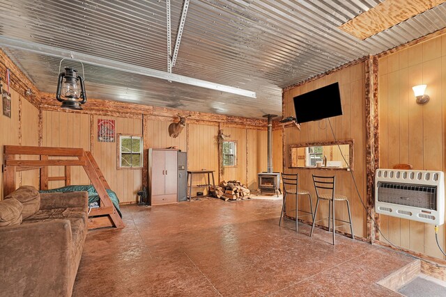 23748 Cutler Rd, Newaygo, MI 49337 - garage with heating unit, a wood stove, and wood walls