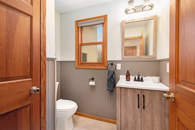 23127 Kendaville Rd, Pierson, MI 49339 - half bath with a wainscoted wall, toilet, vanity, and tile patterned flooring