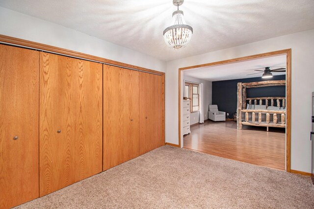 23127 Kendaville Rd, Pierson, MI 49339 - unfurnished bedroom with carpet flooring, a chandelier, a closet, and baseboards