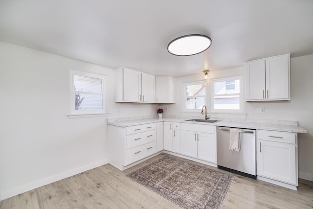923 Maple St, Ludington, MI 49431 - kitchen with dishwasher, a sink, light wood-style flooring, light countertops, and white cabinets