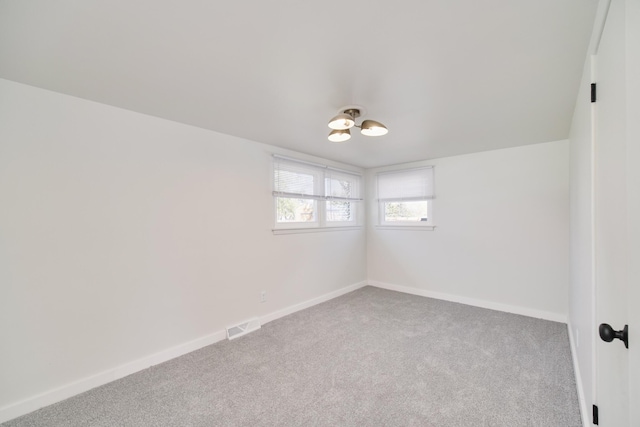 923 Maple St, Ludington, MI 49431 - carpeted spare room featuring baseboards and a chandelier