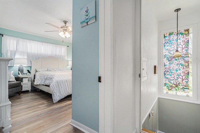 bedroom featuring light wood-style floors, baseboards, and a ceiling fan