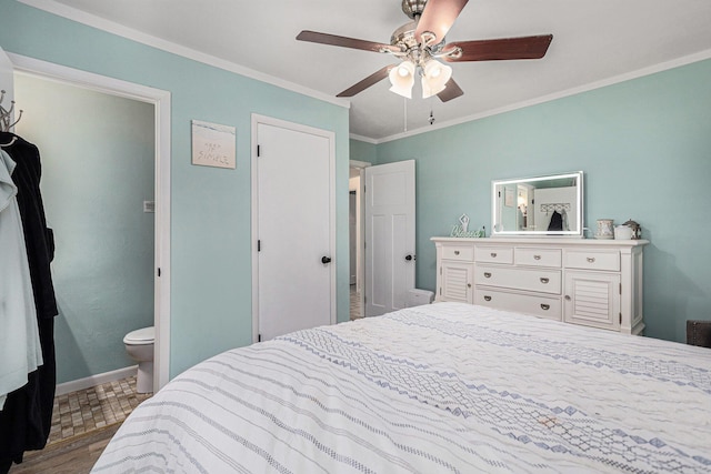 bedroom with crown molding, wood finished floors, baseboards, a ceiling fan, and ensuite bathroom