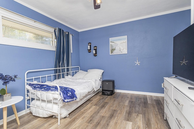 bedroom with wood finished floors, baseboards, a ceiling fan, and crown molding