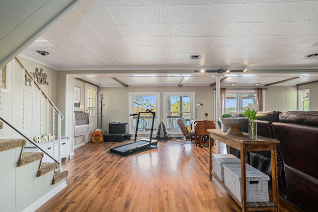 living area with wood finished floors, stairs, and healthy amount of natural light