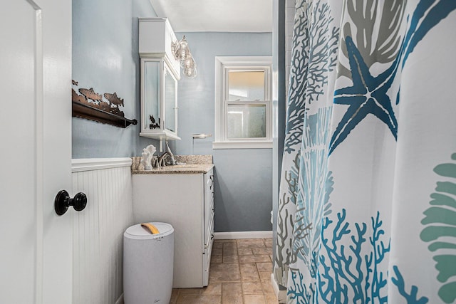 full bathroom with stone tile flooring and vanity
