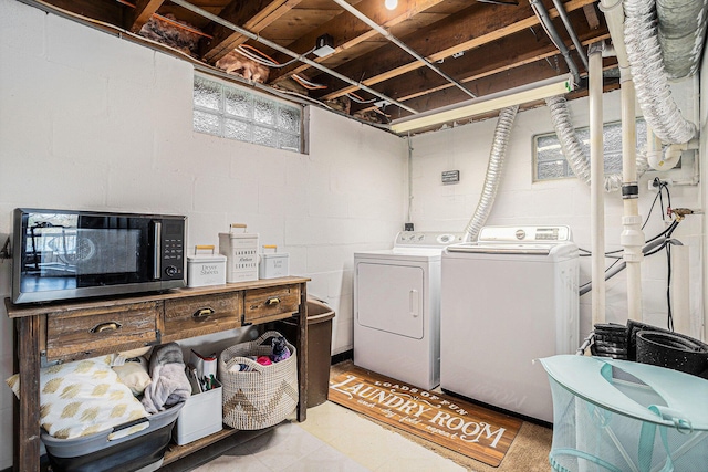 laundry room featuring washing machine and clothes dryer and concrete block wall