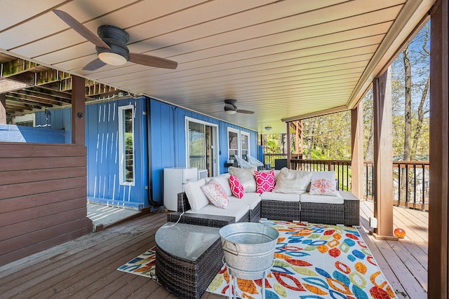 wooden deck with outdoor lounge area and a ceiling fan