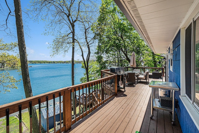 deck with a water view, outdoor dining space, and area for grilling
