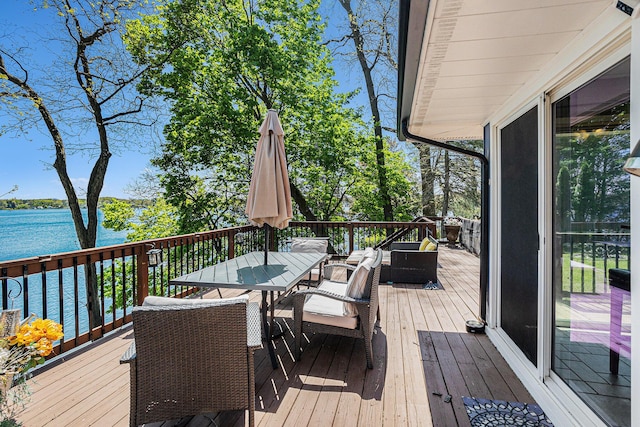 deck featuring a water view and outdoor dining space