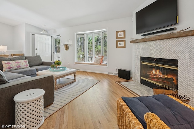 6490 E Chikaming, Sawyer, MI 49125 - living room featuring wood finished floors, a tiled fireplace, baseboards, and lofted ceiling