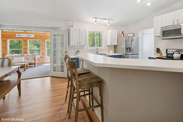 6490 E Chikaming, Sawyer, MI 49125 - kitchen with stainless steel appliances, a breakfast bar, french doors, white cabinets, and rail lighting