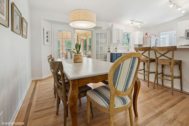 6490 E Chikaming, Sawyer, MI 49125 - dining room featuring rail lighting, light wood finished floors, and baseboards