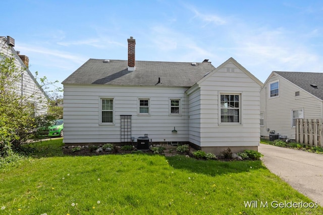 rear view of property with central AC and a chimney
