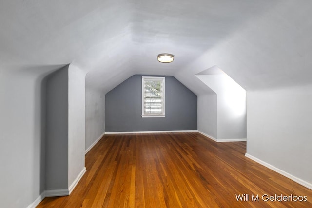 additional living space featuring hardwood / wood-style floors, vaulted ceiling, and baseboards