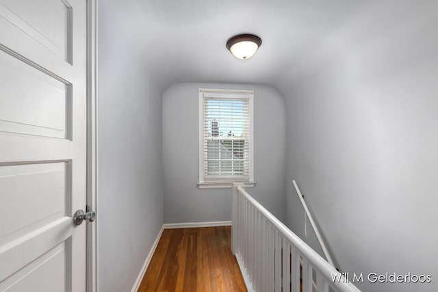 hallway featuring an upstairs landing, wood finished floors, and baseboards