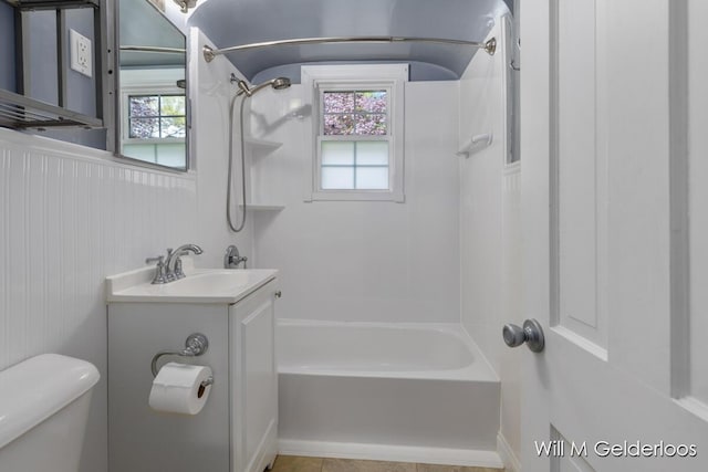bathroom with toilet, healthy amount of natural light, shower / tub combination, and vanity