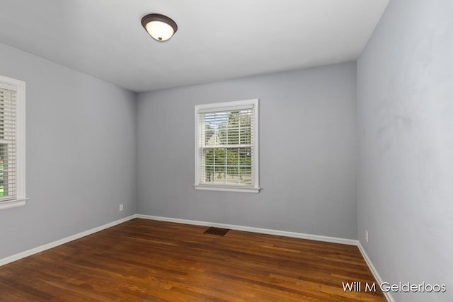 spare room with wood finished floors and baseboards