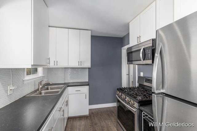 kitchen featuring stainless steel appliances, a sink, dark wood finished floors, and decorative backsplash