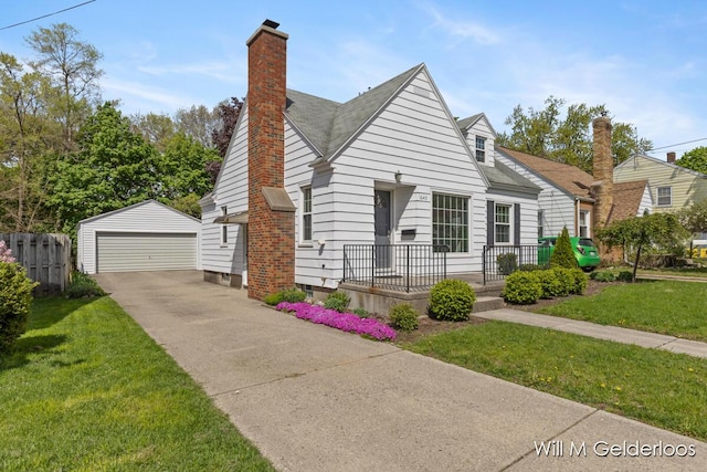 view of front of property with an outbuilding, a detached garage, a chimney, and a shingled roof