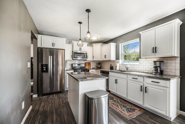 5790 Paxton Ct, Portage, MI 49024 - kitchen featuring appliances with stainless steel finishes, tasteful backsplash, white cabinetry, dark wood-type flooring, and a kitchen island