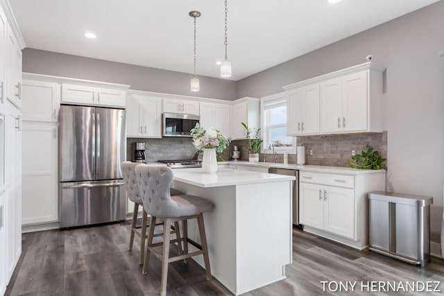 7104 Crimson Ct, Hudsonville, MI 49426 - kitchen with stainless steel appliances, a kitchen island, white cabinetry, tasteful backsplash, and recessed lighting