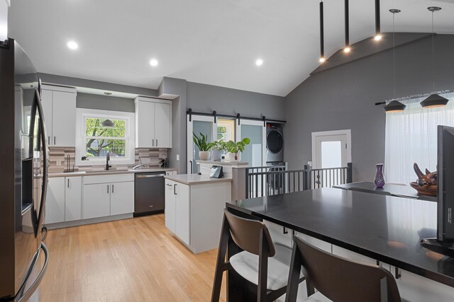 2151 Anderson Dr SE, Grand Rapids, MI 49506 - kitchen featuring stainless steel appliances, white cabinetry, tasteful backsplash, light wood-style floors, and high vaulted ceiling