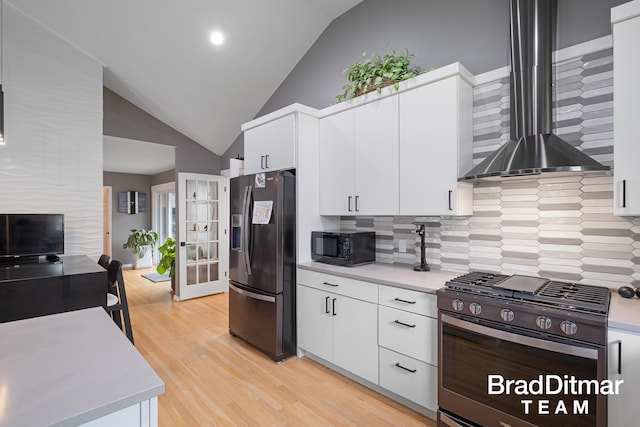 2151 Anderson Dr SE, Grand Rapids, MI 49506 - kitchen with stainless steel appliances, wall chimney range hood, lofted ceiling, tasteful backsplash, and light wood-style floors