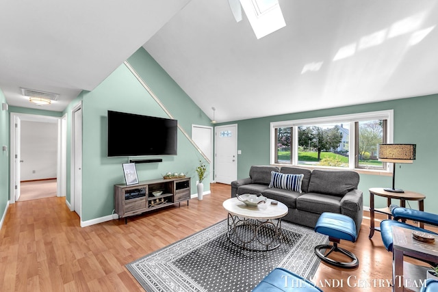 17083 Spahr St, Spring Lake, MI 49456 - living room with a skylight, light wood-style floors, lofted ceiling, and baseboards