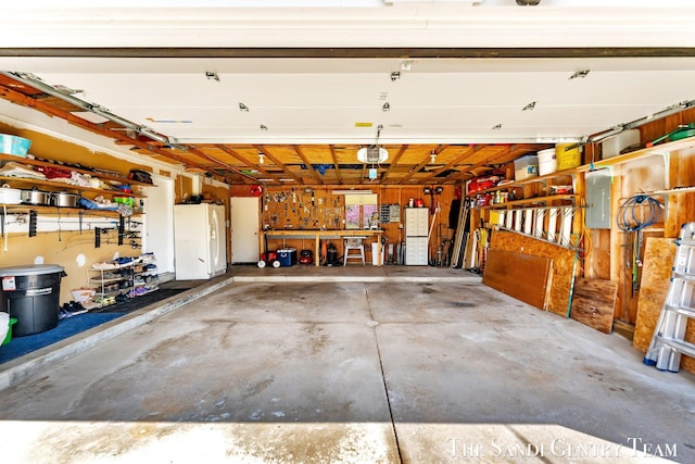 17083 Spahr St, Spring Lake, MI 49456 - garage with white refrigerator with ice dispenser, electric panel, and a garage door opener