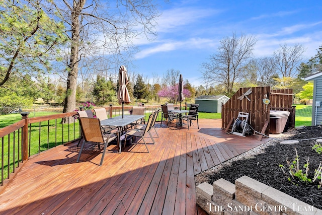 17083 Spahr St, Spring Lake, MI 49456 - wooden deck with outdoor dining space, a storage unit, an outbuilding, and fence