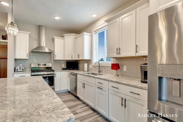 4700 Albright Ct SW Unit 6, Wyoming, MI 49418 - kitchen featuring stainless steel appliances, wall chimney exhaust hood, a sink, white cabinets, and tasteful backsplash