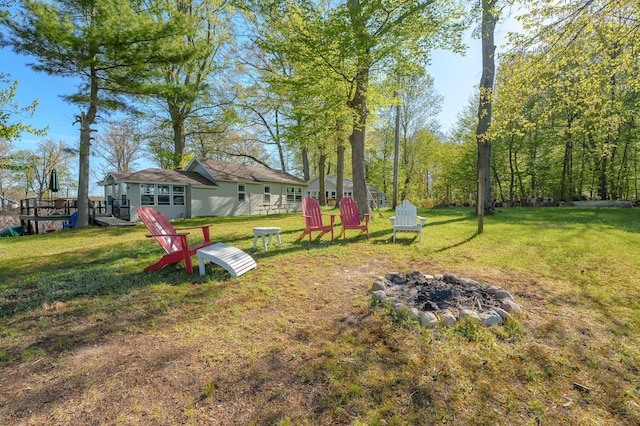 1098210976 Beech Is, Plainwell, MI 49080 - view of grassy yard featuring an outdoor fire pit and a wooden deck