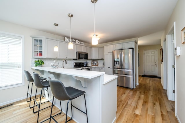 405 Anchors Way, Saint Joseph, MI 49085 - kitchen featuring appliances with stainless steel finishes, a peninsula, light countertops, and a breakfast bar area